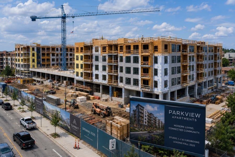 Institutional-scale multifamily development under construction, tower crane above the podium — the asset profile underwritten in this case study
